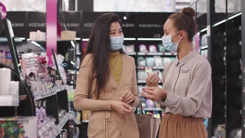 Asian Woman Buying Perfume In Cosmetics Store
