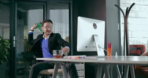 Businessman in the Office in Front of the Computer Showing Anger