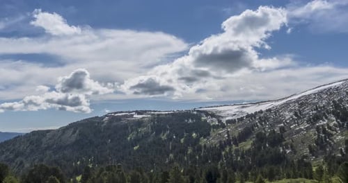 Time Lapse of Cloudscape Behind of the Mountains Top. Snow, Rocks, Cliffs and Deep Blue Sky. High