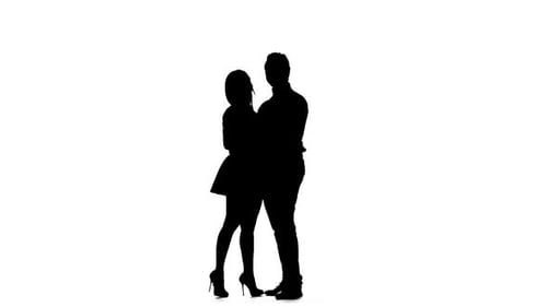 Frau mit einem Mann schaut auf das Poster und wählt einen Film aus. Silhouette. Weißer Hintergrund. Zeitlupe