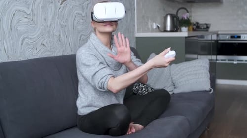 Woman Immersed in Virtual Reality on Couch