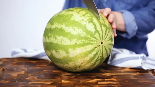 Schritt für Schritt. Rote Wassermelone auf einem Holzschneidebrett schneiden.