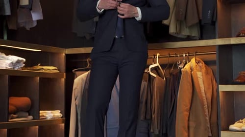 Elegant Man Trying on a Jacket in a Shop