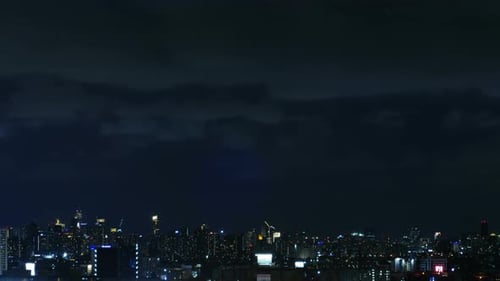 Night Cityscape Under Dark Cloudy Sky