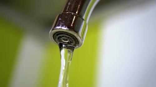 Close Up of Shiny Silver Faucet Flowing Water
