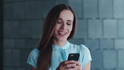Woman Smiling While Using Cell Phone