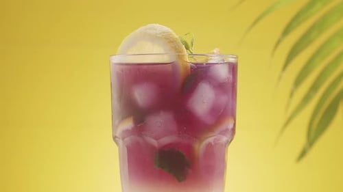 Refreshing Purple Drink with Lemon Slice on Yellow