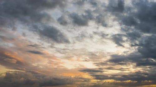 Dramatic Gray Clouds Moving Across Orange Sunset Sky