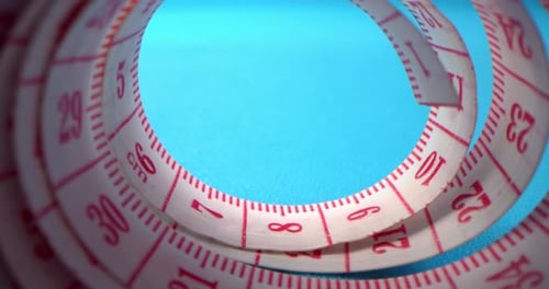 Super Macro Shot of a Measuring Tape Into a Roll of Sewing and Colored Thread on the Background