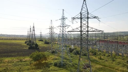 Aerial Cinematic Clip Drone Flies Rising Over a Wheat Field and High Voltage Electric Towers