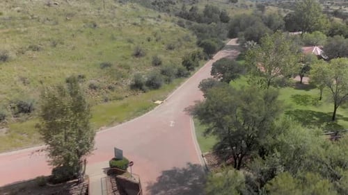 aerial fly over a lodge with green trees during summer time