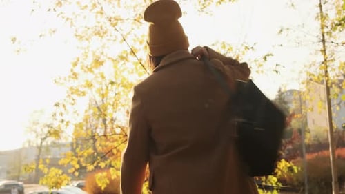 Subject Walking on Street in Autumn Waving