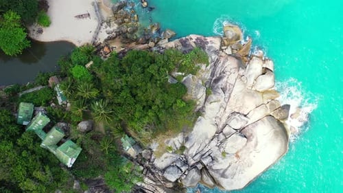 Beautiful big cliff with abstract patterns naturally caved by turquoise lagoon and white sea waves,