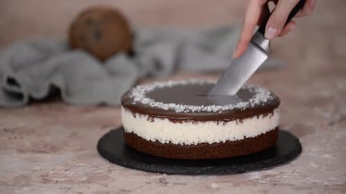 Cutting Delicious Layer Cake With Coconut and Chocolate