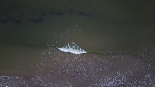 Beautiful aerial view of an old wooden pier at the Baltic sea coastline, overcast day, white sand be