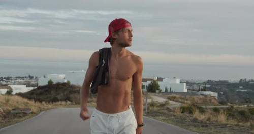 Slim Man In Backwards Cap On Road