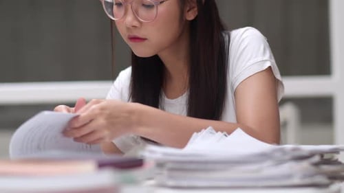 Woman Studying Papers at Desk Close Up