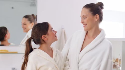 Smiling Mother and Child in Bathroom Wearing Robes