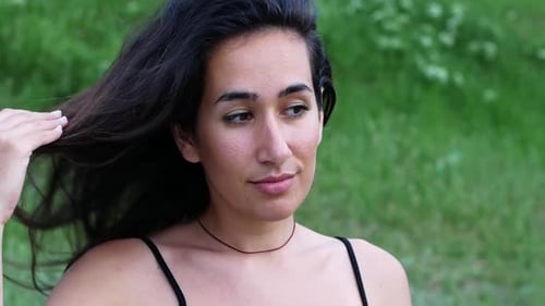 Woman Puts Hair Up in Nature