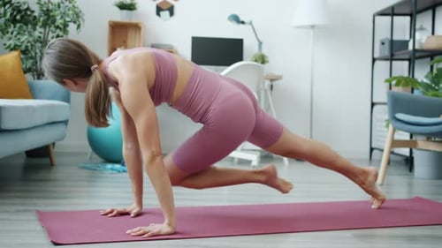 Side View of Motivated Sportswoman Exercising Indoors at Home Concentrated on Physical Activity