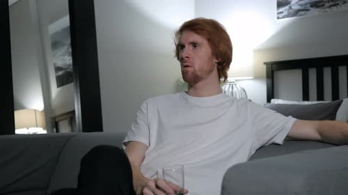 Man Relaxing on Sofa and Drinking Beverage