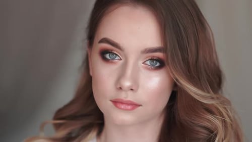 The Girl After Applying Makeup Poses in Front of the Camera.