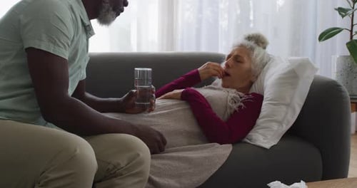 Man Cares for a Sick Senior Woman at Home