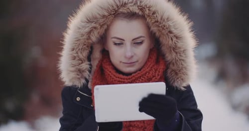 Woman Using Tablet in Snowy Winter Landscape