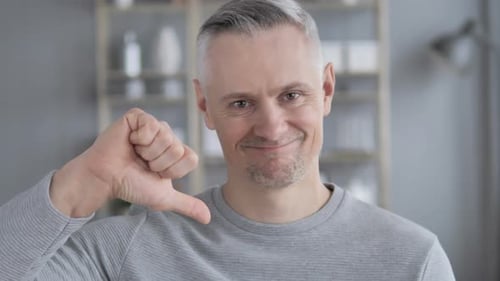 Thumbs Down By Gray Hair Man at Work, Looking at Camera