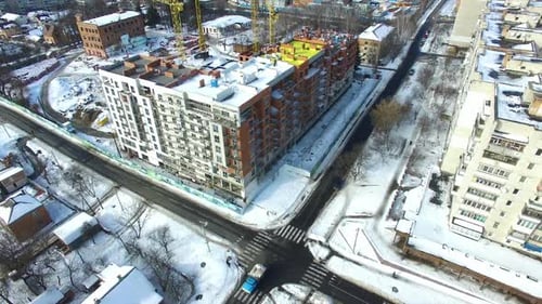 Newly constructed building. Crane and building construction site in winter