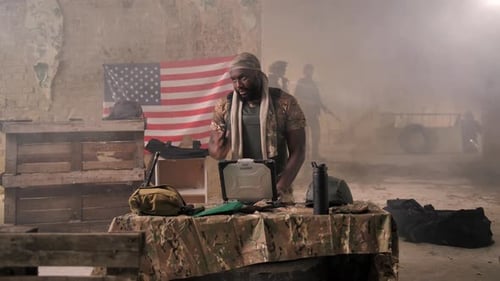 Soldier Using Laptop, Collaborating in Military Building