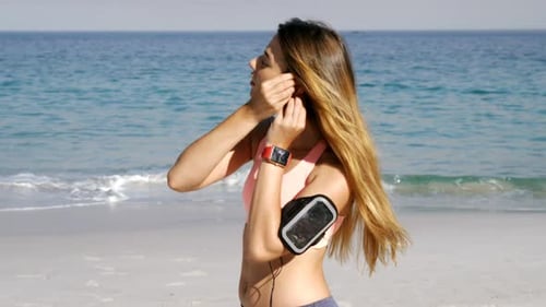 Woman Running on Beach with Headphones