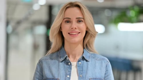 Blonde Woman Smiling in a Bright Workplace