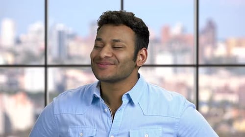 Young Adult Man Smiling Indoors in Urban Setting