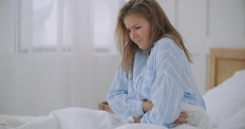 Stomachache. The Redhead Girl Has Awful Stomachache at Her Home. Abdominal Pain, Her Menstrual