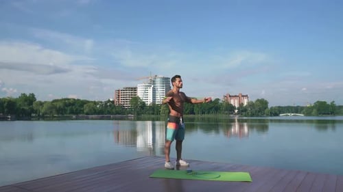 Man Working Out with Resistance Bands by Lake