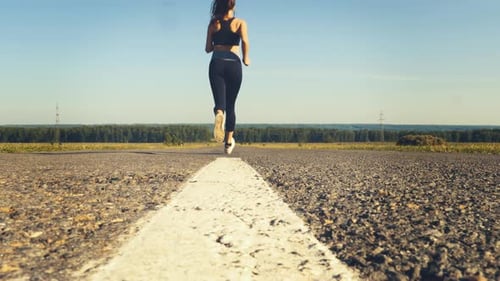 Sporty Woman Jogging on The Road