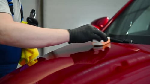 Applying Ceramic Coating to Red Car in Garage