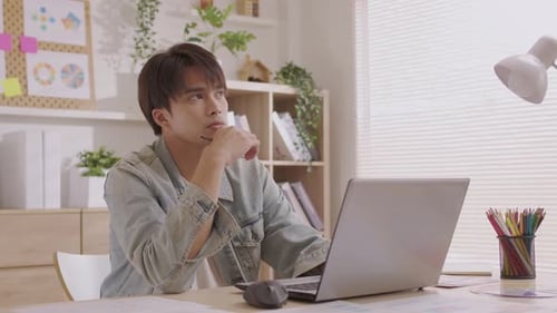 Young Adult Working at Laptop in Bright Office