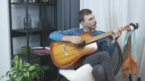 Young Adult Plays Acoustic Guitar and Sings