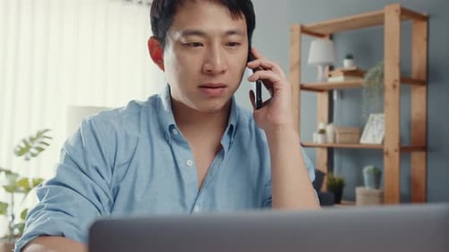 Young Adult on Mobile Phone Using Laptop