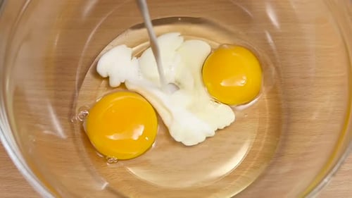 Adding Milk to Eggs in a Bowl