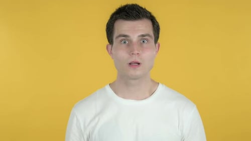 Man Reacts in Surprise on Yellow Background