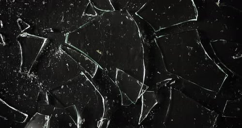 Ein Glas zerbricht in viele Teile