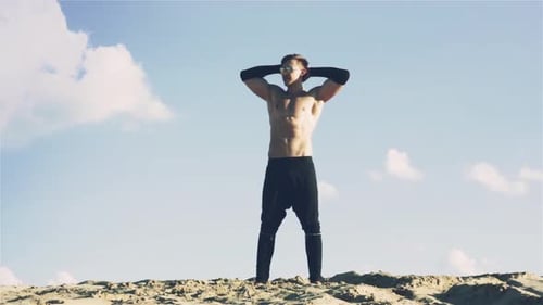 Muscular Man Posing Shirtless in Desert Setting