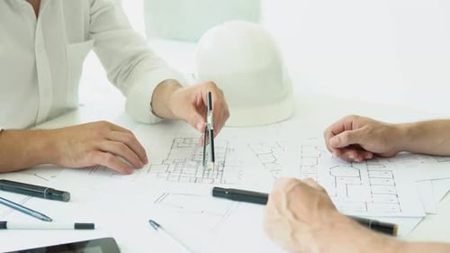 Engineers Team Discussing on the Drawing Table for Planning the Work in the Project and Real Estate