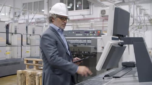 Focused Old Factory Engineer Checking Industrial Machine