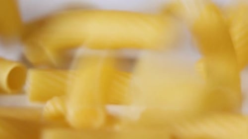 Close Up of Pasta Falling onto White Surface