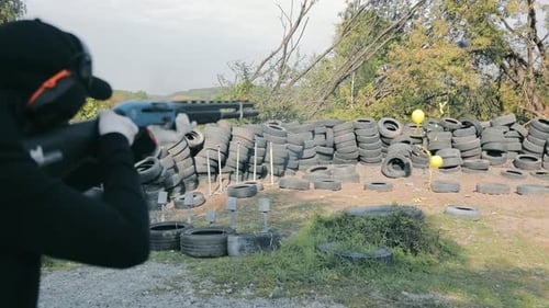 A Woman Shoots with a Smoothbore Hunting Weapon at Yellow Balls