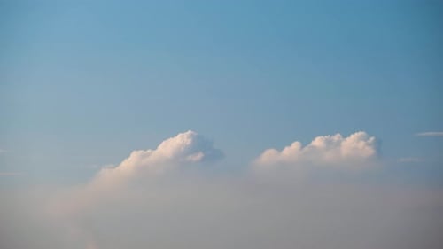Fluffy Clouds Passing in Light Blue Sky